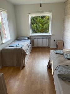 zwei Betten in einem Zimmer mit zwei Fenstern in der Unterkunft Rødt hus in Givskud