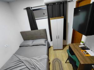 a bedroom with a bed and a desk and a tv at Kurten Hotelaria in Cândido de Abreu