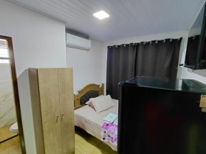 a small bedroom with a bed and a television at Kurten Hotelaria in Cândido de Abreu +8 photos