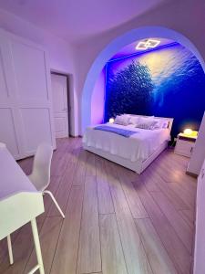 a bedroom with a bed and a blue wall at Blu Suite Ostia in Lido di Ostia +45 photos
