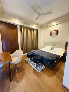 a bedroom with a bed and a table and chairs at Av stays in Greater Noida