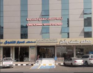 a person walking in front of a building at أجنحة الشمال للشقق المخدومة in Tabuk