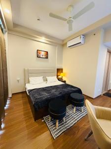 a bedroom with a bed and two chairs in it at Av stays in Greater Noida