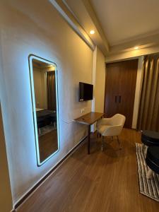 a room with a mirror and a desk with a chair at Av stays in Greater Noida