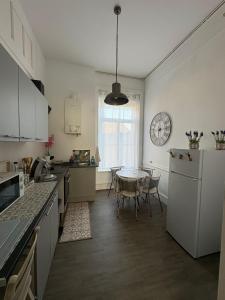 a kitchen with a table and a clock on the wall at La belle époque ardennaise in Sedan
