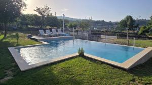 a swimming pool in a yard with chairs around it at Fernandes House in Paredes de Coura
