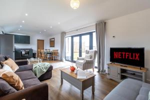 a living room with a couch and a tv with netflix at The Stables in Sibbertoft