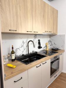 a kitchen with a sink and a stove top oven at Foel Apartament in Tirana