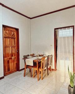 a dining room with a table and chairs and a door at Casa Clara La Union in Dalumpinas Oeste