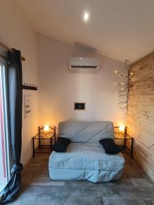a bed in a room with two lamps on the wall at Dax Jardin Studio in Dax