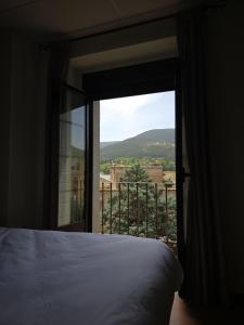 a bedroom with a bed and a window with a view at Hostal La Cigüeña in El Espinar