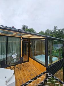 a screened in deck with a table and chairs at Merisi Horizon 2 in Silibauri