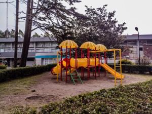 a playground with yellow and red equipment in a park at Spa vacacional in Mar del Plata