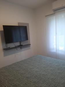a bedroom with a flat screen tv on a wall at Spa vacacional in Mar del Plata