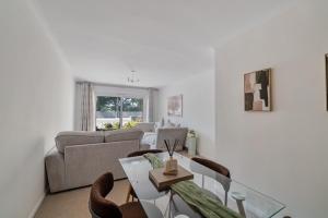a living room with a couch and a table and chairs at Fairways - Flat 3 in Weston-super-Mare