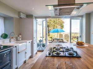 a kitchen with a stove and a table with an umbrella at 4 Bed in Holsworthy oc-77663 in Milton Damerel