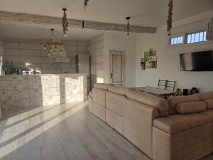 a living room with a large couch and a kitchen at La Rocina in Sanlúcar de Barrameda