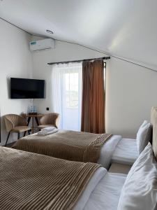 a hotel room with two beds and a television at Davos hotel and tours in Pʼarakʼar