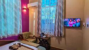 a room with a tv hanging on a wall at NIGO EXECUTIVE LODGE Mahenge in Mahenge