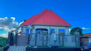 a house with a red roof on a street at NIGO EXECUTIVE LODGE Mahenge in Mahenge