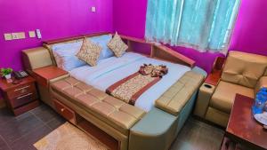 a large bed in a room with purple walls at NIGO EXECUTIVE LODGE Mahenge in Mahenge