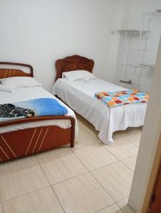 two beds sitting next to each other in a room at Vilma's BnB in Mérida