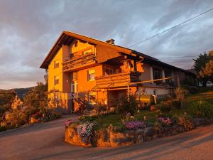ein Haus auf einem Hügel mit Blumen davor in der Unterkunft Bobnarica in Grahovo
