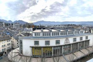 a large white building with yellow doors in a city at Studio Léman in Chambéry