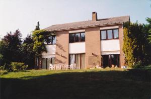 a large brick house with chairs in front of it at Prince d'Orange Bed & Breakfast in Braine-lʼAlleud