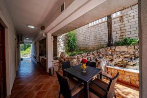 a patio with a table and chairs and a stone wall at Villa Castello in Korčula