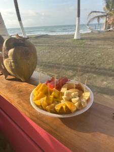 a plate of fruit on top of a table near the beach at Karpatty Mar Cabañas in San Bernardo del Viento +34 photos