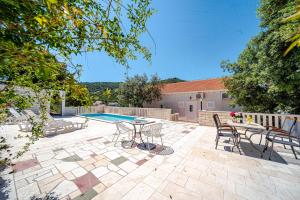 a patio with a table and chairs and a pool at Villa Castello in Korčula