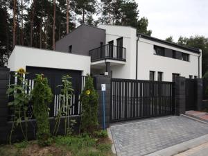 a white house with a black fence at Baltic Inn in Ustka