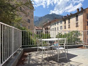 a table and chairs on a balcony with buildings at Appartements Corte centre in Corte