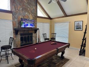 a pool table in a room with a stone fireplace at Escape to Tropical Tampa in Tampa