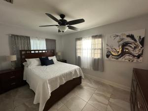 a bedroom with a bed with a ceiling fan at Escape to Tropical Tampa in Tampa +29 photos