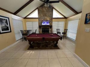 a living room with a pool table and a fireplace at Escape to Tropical Tampa in Tampa