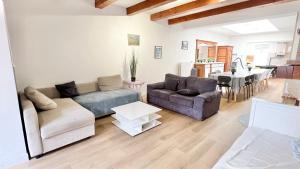 a living room with two couches and a dining room at La Maison des Poutres & Lumières - Emile Zola in Croix