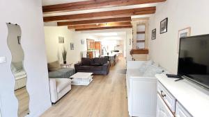 a living room with a couch and a flat screen tv at La Maison des Poutres & Lumières - Emile Zola in Croix