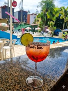 a drink sitting on a table next to a pool at Pousada Suarez in Penedo
