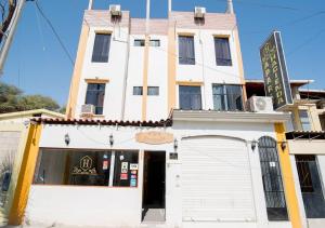 a white building with a sign in front of it at Ayenda Apart La Hacienda in Piura