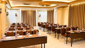 a room filled with tables and chairs in a room at Atiyan Hotel Syariah in Bukittinggi