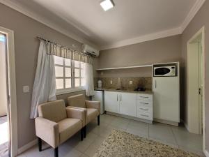 a kitchen with two chairs and a counter top at MD House Express - Petrópolis in Passo Fundo