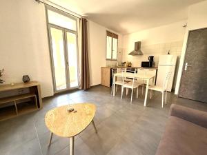 a living room with a table and a kitchen at Appartements Corte centre in Corte