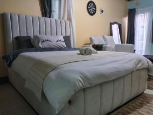 a bedroom with a large white bed and a chair at New Era Homes in Kimana