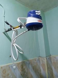 a blow dryer hanging on the wall of a bathroom at New Era Homes in Kimana +28 photos