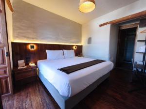 a bedroom with a large white bed in a room at El Balcón in Cusco