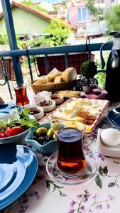 a table topped with plates of food and a cup of tea at Mimosa House Ayvalık in Ayvalık