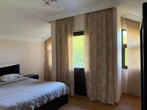 a bedroom with a bed and a window with curtains at Alazani 2015 in Duisi