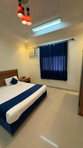 a bedroom with a bed and a blue curtain at غيوم ابها - شقق مخدومه in Abha +4 photos